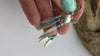 Video showcasing A classic Native American design. These earrings feature tripple dangling silver feathers  topped with Turquoise beads hanging from an intricate concho charm. The earrings are a hook style and are handmade by a Native American Artist. 