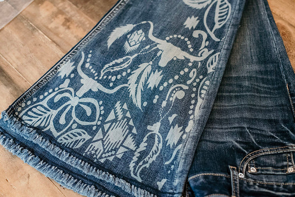 The bottom of the leg of a medium blue pair jeans with a bleached out buffalo and aztec print. These luxury stretch jeans are beautifully adorned with embellishment in southwestern patterns to give you a truly unique core piece for your wardrobe. UK Exclusive Grace in LA Stockist, Get Grace in LA in UK. 