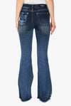 A super fun and sexy jeans design with a bleached out buffalo and aztec print on the back pockets and lower leg shown modeled by a woman. Back viewview.