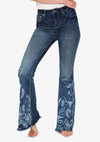 A super fun and sexy jeans design with a bleached out buffalo and aztec print on the back pockets and lower leg shown modeled by a woman. Front view.